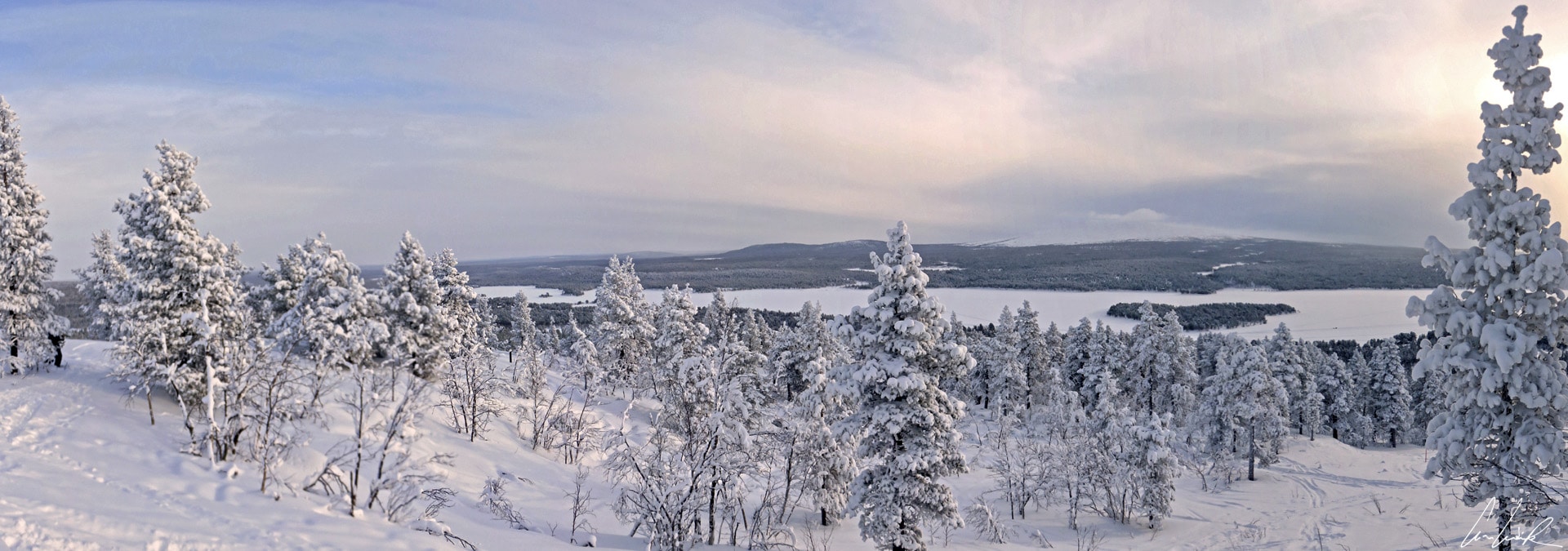 Du sommet de la colline Jyppyrä (700 mètres), on a une vue panoramique imprenable sur les arbres enneigés et le lac gelé Ounasjärvi.