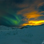 Notre première aurore boréale. Le ciel norvégien se pare de filets verts qui semblent se faufiler entre les nuages orangés.