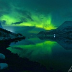 Dans le magnifique Ersfjord en Norvège, les aurores boréales se forment pile dans l'alignement du fjord et se reflètent dans l’eau.