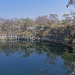 The lake Otjikoto is an expanse of turquoise water well hidden from sight. It looks like a deep circular hole surrounded by steep, 65-foot dolomite walls.