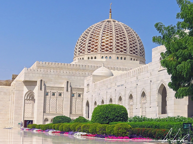 Le dôme de la Grande Mosquée du Sultan Qaboos en treillis d'or domine les parterres de marbre blanc et de fleurs colorées.