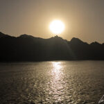 Vu depuis la mer d’Oman, le spectacle du coucher de soleil sur les hautes falaises qui plongent à pic dans la mer est saisissant !