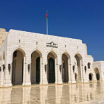 The architecture of the Royal Opera House in Muscat is in the style of Omani public buildings with colonnades and white stone towers.