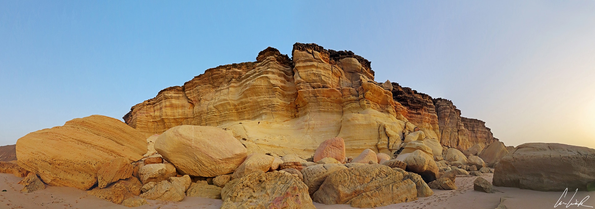 Ras al-Jinz beach has beautiful and colorful cliffs. The orange-colored rock is carved and sculpted.