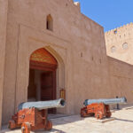 The main gate of Jabreen Castle is set between thick defensive walls and is flanked by two cannons.