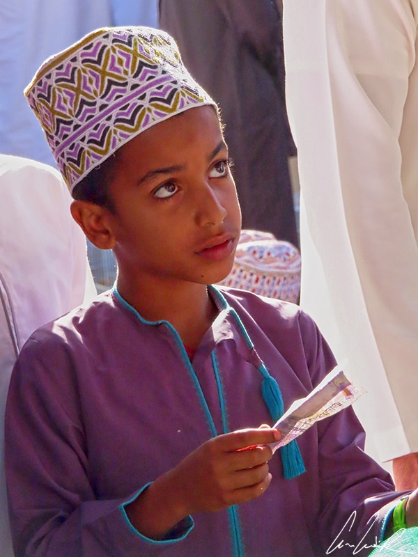 Un jeune garçon vêtu de sa dishdasha couleur violette et de son kuma assorti, a décidé d’investir quelques rials dans des poussins.