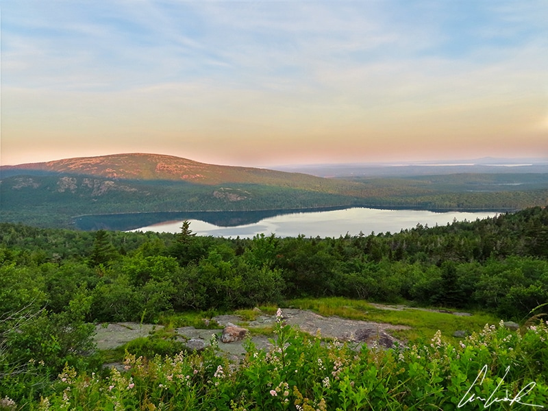 In Acadia National Park, a magnificent view of Eagle Lake in the early morning as the sun just rose. The rounded mountains are reflected in the waters of the lake.