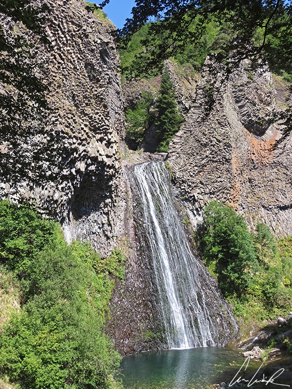 Les eaux de la cascade de Ray Pic tombent de 60 mètres, en deux chutes successives, entre les orgues basaltiques de l’ancien volcan de la Fialouse.