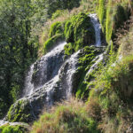 La cascade de Baume-les-Messieurs est constitué de roches couvertes de mousses couleur émeraude sur lesquelles perlent des rideaux d’eau.