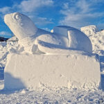 A snow sculpture in Luleå representing a turtle with its head raised.