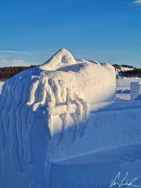 Sur les quais de la mer de Botnie à Luleå, une sculpture de neige représentant un visage avec le nez, la bouche, les yeux et les cheveux etc.
