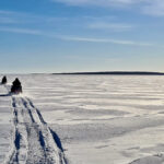 La balade en motoneige commence sur la mer gelée, une grande étendue blanche à perte de vue.