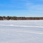 Sur la mer gelée de Botnie, seules quelques cabanes de pêcheurs viennent rompre la monotonie de cette grande étendue blanche.